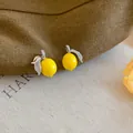 Dettaglio ravvicinato di orecchini a lobo a forma di limone con zirconi. - Stud orecchini / Giallo