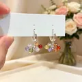 Close-up of colorful glass bead hoop earrings with faceted candy-colored spheres. - Hoop Earrings (Silver) / Colorful