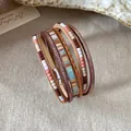 Vista dettagliata di bracciale bohémien multistrato in pelle con perline e chiusura magnetica - Marrone