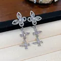 Detaillierte Makroansicht von silbernen Schmetterlings-Ohrringen mit Zirkonia-Besatz. - Schmetterling Quaste Stil / Silber