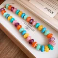 Detailed macro shot of vibrant marbled acrylic bead necklace with elegant gold spacers - Necklace / Colorful