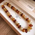 Detailed macro view of retro amber-tone acrylic swirl bead necklace in jewelry box - Necklace / Brown