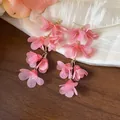 Detail view of pink chiffon flower tassel earrings featuring delicate golden chain accents - Pink