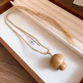 Detail view of handmade wooden mushroom pendant necklace with woven cotton cord - Mushroom Pendant Necklace / Necklace-Coffee