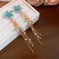 Vue détaillée de boucles d'oreilles vintage à fleurs bleues avec perles colorées - Aiguille en argent / Or-Bleu