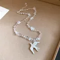 Detailed shot of clear crystal beads and a brushed silver swallow bird pendant necklace - Swallow Clavicle Necklace / Silver