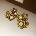 Macro detail of vintage style flower stud earrings featuring pearls and rhinestones - Silver Earring Post Style / Gold