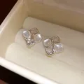 Elegant vintage square resin and cubic zirconia stud earrings inside a cream jewelry box - White
