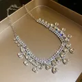 Macro detail of elegant silver-tone necklace featuring pavé rhinestones and heart charms - Necklace / Silver