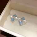 Elegant square stud earrings with light blue zircon and white resin in a jewelry box - Blue
