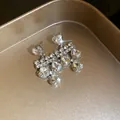 Close-up of heart-shaped rhinestone drop earrings with sparkling crystal accents - Earrings / Silver