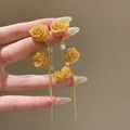 Vue détaillée de boucles d'oreilles rose en tissu doré avec zircons et glands longs - Style de tige d'oreille en argent / Or