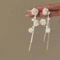 Vue détaillée de boucles d'oreilles élégantes en roses de tissu blanc avec zircone - Style de tige d'oreille en argent / Argent