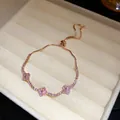Close-up of pink clover bracelet with adjustable sliding clasp in jewelry box - Rose Gold-Pink