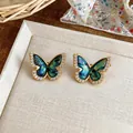 Macro view of elegant gold butterfly earrings with blue marbled inlay and zircons - Butterfly Style (HE32373) / Gold-Green
