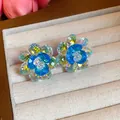 Macro view of exquisite blue glass flower stud earrings in jewelry tray - Blue & White