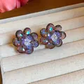 Close-up detail of colorful faceted glass flower stud earrings in a velvet jewelry box - Purple
