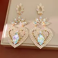 Close-up of sparkling crystal heart earrings with iridescent floral accents. - Silver Post AB Color / Gold