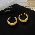 Close-up of elegant gold textured hoop earrings with a vertical ribbed pattern design. - Round Textured Style (HE33762) / Gold