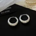 Macro detail view of silver textured hoop earrings with minimalist ribbed pattern. - Round Textured Style (HE33762) / Silver