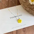 Detail shot of a colorful beaded dopamine necklace with a vibrant yellow flower pendant - Silver/Yellow