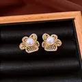 Vue détaillée de boucles d'oreilles fleur en or avec perle et pavé de zircons. - Style Pétale (HE34149) / Or