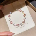 Macro view of gold bracelet with pink and clear cubic zirconia stones on gift pouch - 25# Bracelet