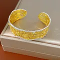 Vista dettagliata del bracciale traforato in pizzo retrò francese nei toni oro e argento - Oro con Bordo Argento