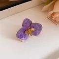 Primo piano di un orecchino vintage a fiore in smalto viola con centro dorato. - Anello / Oro Ecologico / Viola