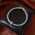 Macro detail of the turquoise braided rope and silver chain bracelet on a black box - Blue Rope Style / 18cm