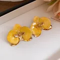 Dettaglio di eleganti orecchini a lobo a fiore in smalto giallo con finitura oro vintage. - Stud orecchini / Giallo