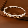 Primo piano di un bracciale rigido a pizzo vintage con accenti dorati e strass brillanti - Argento e Oro