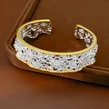 Vista dettagliata del bracciale rigido vintage con bordi a perline dorate e pizzo traforato - Argento Bicolore