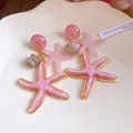 Elegant pink resin starfish dangle earrings with gold edges for vacation style. - Pink