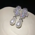 Primer plano de elegantes pendientes de perlas en gota con circonitas brillantes - Plateado