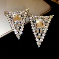 Elegant triangle crystal stud earrings featuring a large rectangular central rhinestone - White