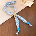 Detail view of ocean theme scarf necklace with starfish pendant and sea shell patterns - Gold Alloy Starfish Pendant