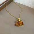 Detailed view of a gold chain necklace featuring a striped brown resin elephant pendant - Elephant Pendant / Brown