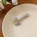 Gros plan d'une pince à cheveux élégante en zircone avec pierres violettes et petit ours - Jaune