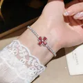Detailed view of elegant flower bracelet featuring red zircon petals worn on a wrist. - 41# Bracelet