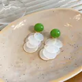 Detailansicht von minimalistischen grünen Harz-Clip-Ohrringen mit weißen Quasten - Clip-Ohrringe / Grün-Weiß