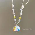Detail of beach necklace with hand-painted shell pendant and colorful beads - White-Yellow