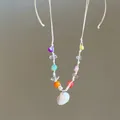 Detail of beach style necklace with colorful beads and a white seashell pendant - White-Yellow