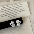 Vista dettagliata di orecchini a fiore in argento con cristalli sfaccettati - Bianco
