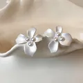Detail view of matte white floral earrings with pearl center accents - Silver Post (HE32297-1) / White