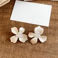 Detailed view of white flower stud earrings with elegant pearl centers - 925 Silver Post Style / White