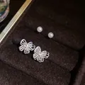 Detailed close-up of silver butterfly earrings with elegant white pearl studs. - Butterfly And Pearl Set / Silver