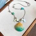 Ocean-inspired beach style necklace with gradient teal shell pendant and starfish charms - Blue Yellow and Green