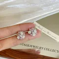 Macro detail of floral stud earrings featuring lavender pearls and sparkling zircons - Unique Flower Shape (HE34161) / Silver Post White and Purple