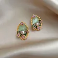 Macro view of exquisite vintage floral enamel earrings with pearl detail and golden frame - Silver Earring Post Style / Pink-Green